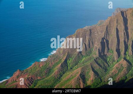 Close-up scenic view from the green covered mountain cliffs of the Napali Coast along the Kalalau Trail on the Hawaiian Island of Kauai, against th... Stock Photo