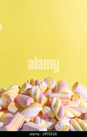 Colourful marshmallows against a yellow background Stock Photo