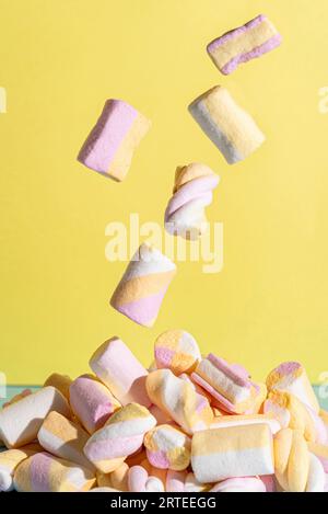 Flying marshmallows against a yellow background Stock Photo