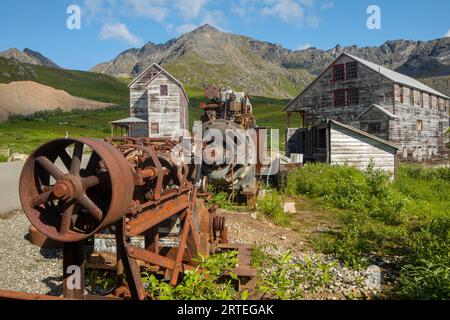 Old mining buildings, with walking trail through them, and old rusty mining equipment, on a sunny day at Independence State Mine Historical Park in... Stock Photo