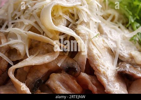 Pasta with cheese, chicken and mushrooms in a plate, close-up Stock Photo