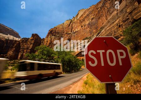 Propane powered shuttle bus passes a stop sign in Zion National Park; Utah, United States of America Stock Photo