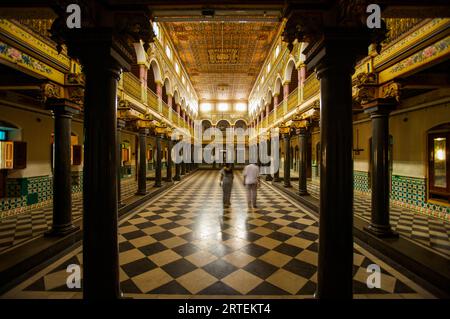 Man and woman walk inside a mansion in Chettinad; Chettinad, Tamil Nadu, India Stock Photo