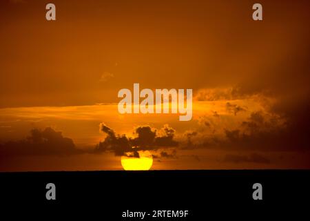 Brilliant golden sun setting over the Caribbean Sea, Tobago; Pigeon Point, Tobago, Republic of Trinidad and Tobago Stock Photo