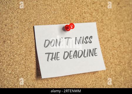Note with reminder Don't Miss The Deadline attached to cork board Stock Photo