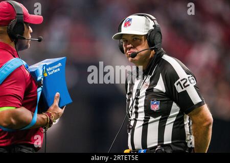 Referee Brad Rogers (126) views the instant replay on a Microsoft