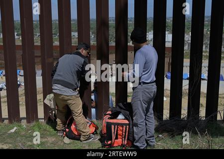 Tijuana, Baja California, Mexico. 12th Sep, 2023. Around a hundred people are stuck between the two US-Mexico border fences dividing Tijuana and San Diego on Tuesday, September 12, 2023, as viewed from Tijuana, Mexico. The migrants are from countries in South America, Central Asia, Eastern Europe and Africa. All are seeking a chance to enter the US via asylum status, as some lost patience in the process of getting appointments through the CBP One application and crossed illegally out of desperation, some waiting months. Migrants claim that the appointment system is over saturated and is di Stock Photo