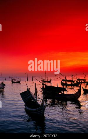 Indonesia, Bali, Jimbaran Bay, With Many Fishing Boats Anchored, Red Sunset Sky Stock Photo