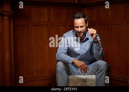 Smiling mid adult man sitting on chair Stock Photo