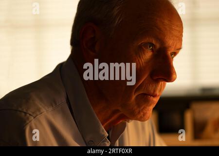 Portrait of thoughtful senior man looking away at home Stock Photo