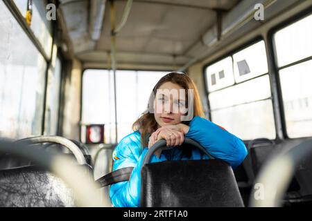 Portrait of woman looking through window while sitting in tram Stock Photo