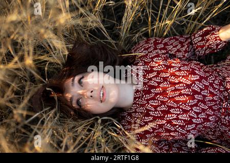 Directly above view of woman lying on cereal plants in field Stock Photo