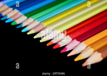 Close up of a row of colored pencils isolated on black Stock Photo