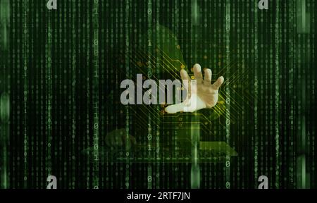 A hacker behind binary code, stream of data, able to break through cyber security and reaches his hand out to steal your personal information Stock Photo
