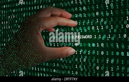 A hacker hand able to find a password hidden in the binary code, and stream of data, and is about to take it to control your personal identity Stock Photo
