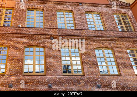 red brick classic industrial building facade with multiple windows. Stock Photo