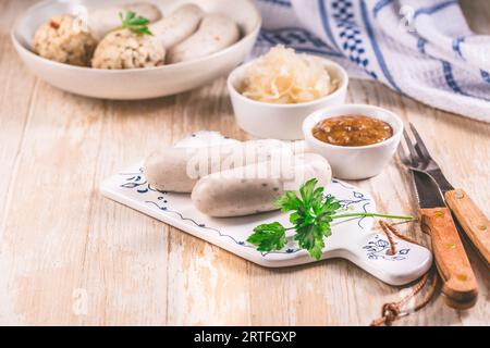 Bavarian white sausages with sauerkraut and bread dumplings, with mustard. Stock Photo