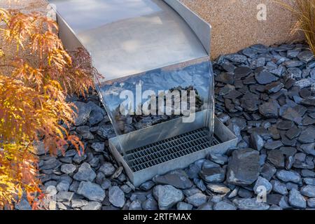 Modern pondless garden waterfall in a backyard with slate stones Stock Photo