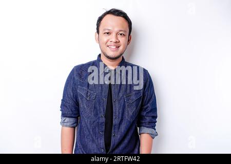 A portrait of a smiling Asian man dressed in a blue shirt, isolated by white background Stock Photo