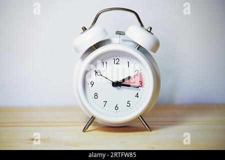 Vintage alarm clock showing change from daylight saving time and fall back to standard time, copy space, selected focus Stock Photo