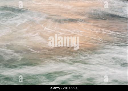 A background closeup of ocean waves, near the shoreline. The waves have a sense of movement. Stock Photo