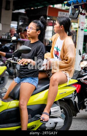 Local Thai people, tourists and residents rush past the busy junction of Soi Buakhao and Soi Lengkee in Pattaya Thailand on mopeds and motorbikes. Stock Photo