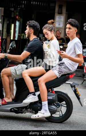 Local Thai people, tourists and residents rush past the busy junction of Soi Buakhao and Soi Lengkee in Pattaya Thailand on mopeds and motorbikes. Stock Photo