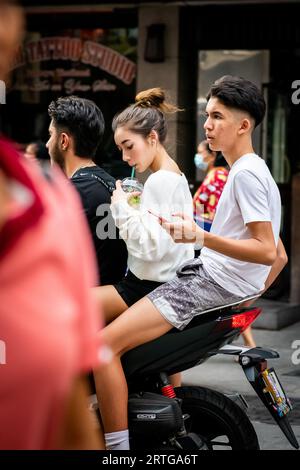 Local Thai people, tourists and residents rush past the busy junction of Soi Buakhao and Soi Lengkee in Pattaya Thailand on mopeds and motorbikes. Stock Photo