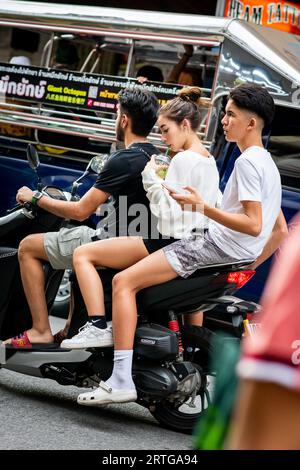 Local Thai people, tourists and residents rush past the busy junction of Soi Buakhao and Soi Lengkee in Pattaya Thailand on mopeds and motorbikes. Stock Photo