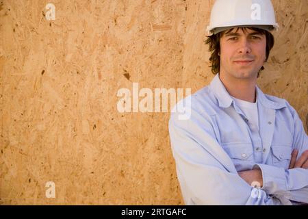 Portrait of a young man wearing hard hat at construction site Stock Photo
