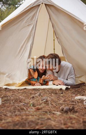 Young couple lying in a tent entrance Stock Photo