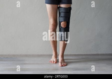 Patient standing with knee brace support after do posterior cruciate ligament surgery. Healthcare and medical concept. Stock Photo