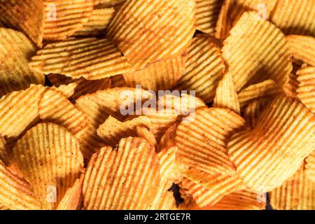 Crispy fresh potato chips snack texture background, Golden chips background with texture Stock Photo