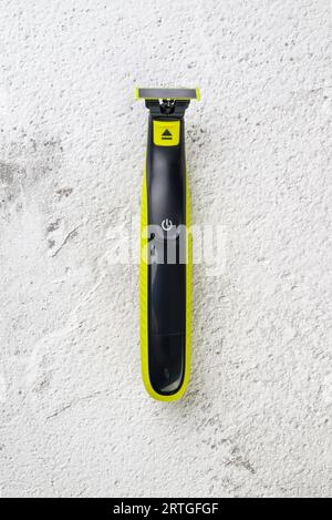 Rechargeable electric razor for shaving and trimming black and yellow beard Stock Photo