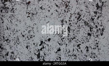 dichromatic black and white background with an ornate pattern and swirls of white colors on dark glass, graphic abstraction with a chaotic pattern Stock Photo