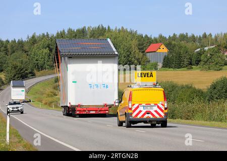 Two exceptional load transports of a prefab cabin in highway traffic, escort vehicle assisting, car gives way. Salo, Finland. September 7, 2023. Stock Photo