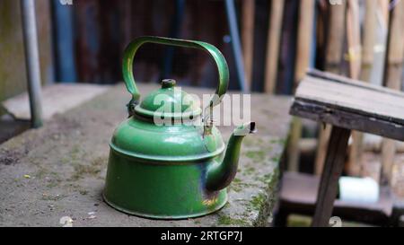 the old kettle was dull green in dusty, scratched and slightly rusty condition Stock Photo