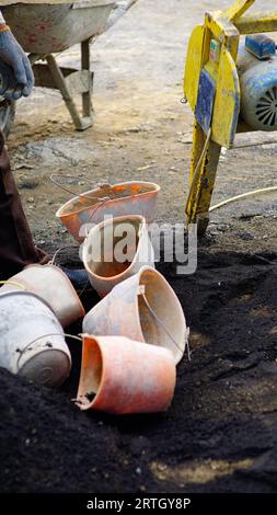 several plastic buckets in dirty conditions scattered around the workplace. Stock Photo