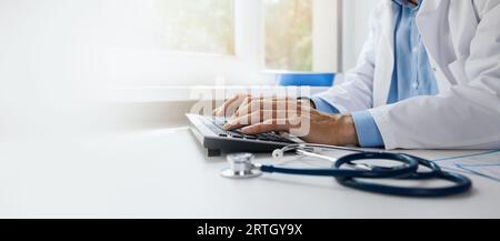 doctor typing on computer keyboard. working in hospital office. online medical consultation, communication and ehealth concept. banner with copy space Stock Photo
