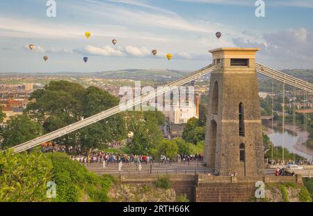 A vibrant collage of hot air balloons, in a myriad of hues, floats above the iconic city of Bristol during the International Balloon Fiesta Stock Photo