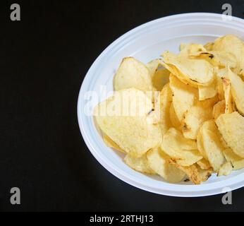 Crispy potato chips in a plastic disposable plate Stock Photo