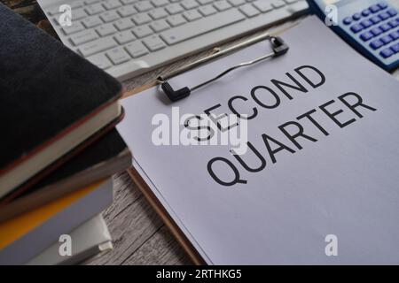 Close up image of paper clipboard with text SECOND QUARTER on office desk Stock Photo