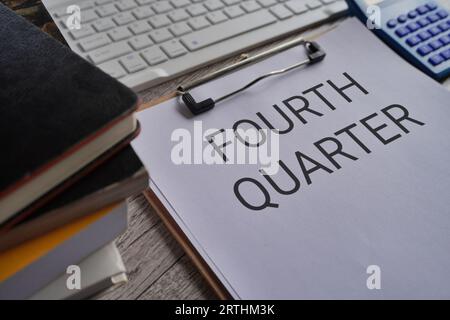 Close up image of paper clipboard with text FOURTH QUARTER on office desk Stock Photo