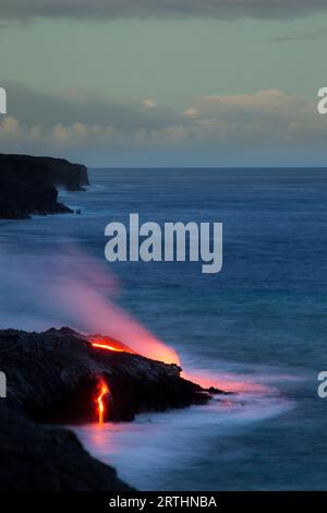 Glowing lava flows into the sea in Hawaii Volcanoes National Park on Big Island, Hawaii, USA Stock Photo