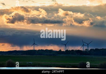 Turbines and dranatic rainy sky at sunset, Oldenburg Stock Photo