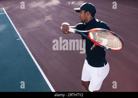 Tennis player on hard court exercising at sunset Stock Photo