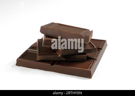 Broken chocolate bar is isolated on a white background. Close-up Stock Photo