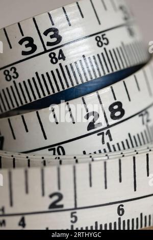 Curled up tape measure in inches and centimetres Stock Photo