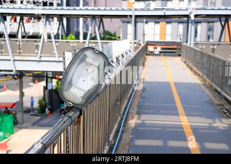 A broken street lamp lying on the pedestrian walkway. Stock Photo