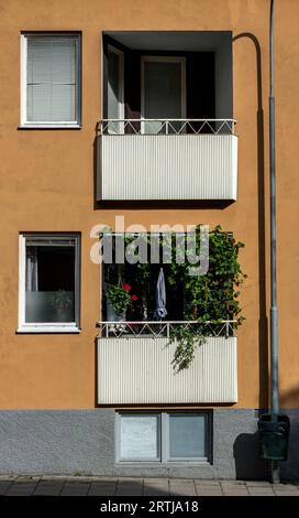 Contrasting balconies, one empty and one full of flowers and plants Stock Photo